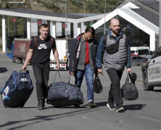 Russian men carry their luggage after crossing the border at Verkhny Lars between Georgia and Russia, September 27, 2022, in Georgia.,Zurab Tsertsvadze/AP Photo // The American Prospect 