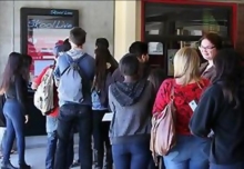High school students line up to use the new SkoolLive kiosks